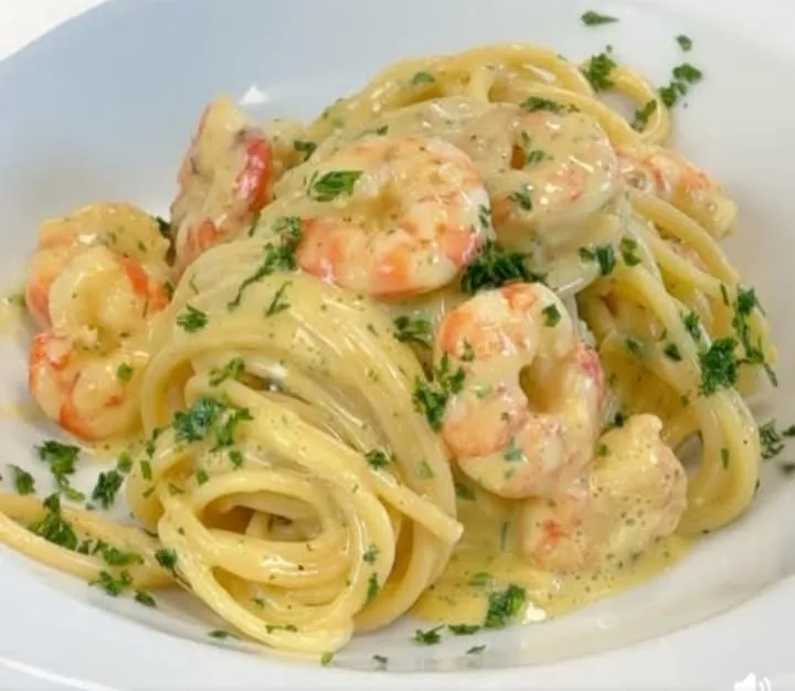 Pasta with prawns, a creamy sauce and chopped herbs
